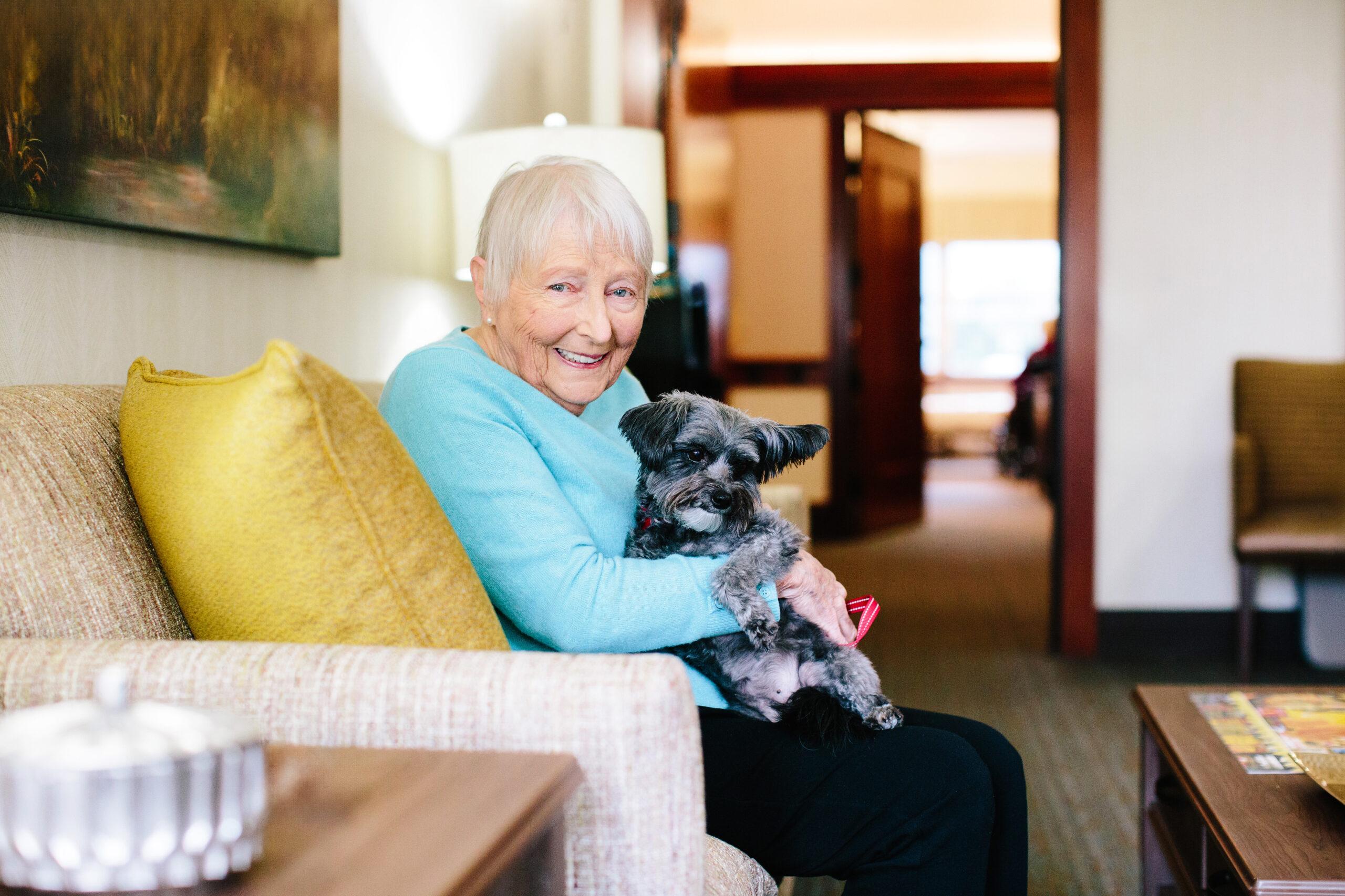 Older woman holds a dog