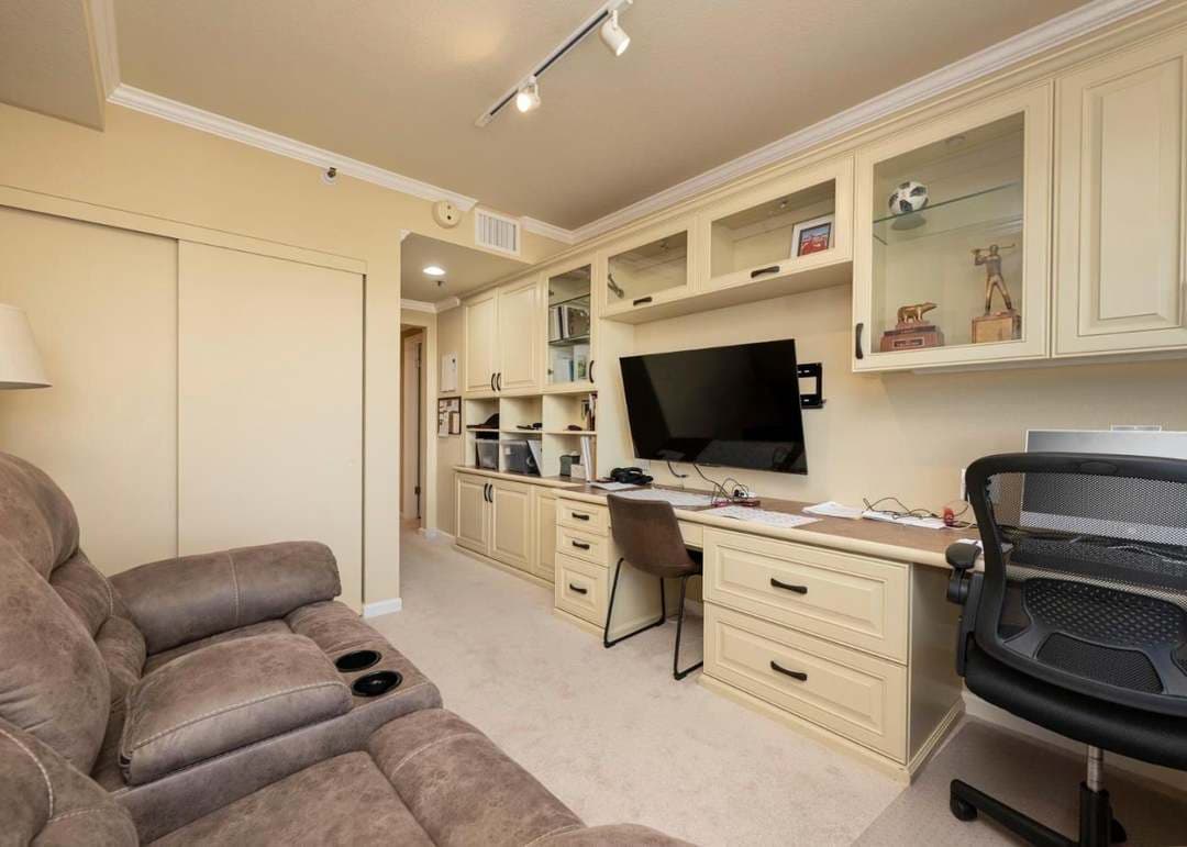 spare bedroom set up as den with built-in cabinetry