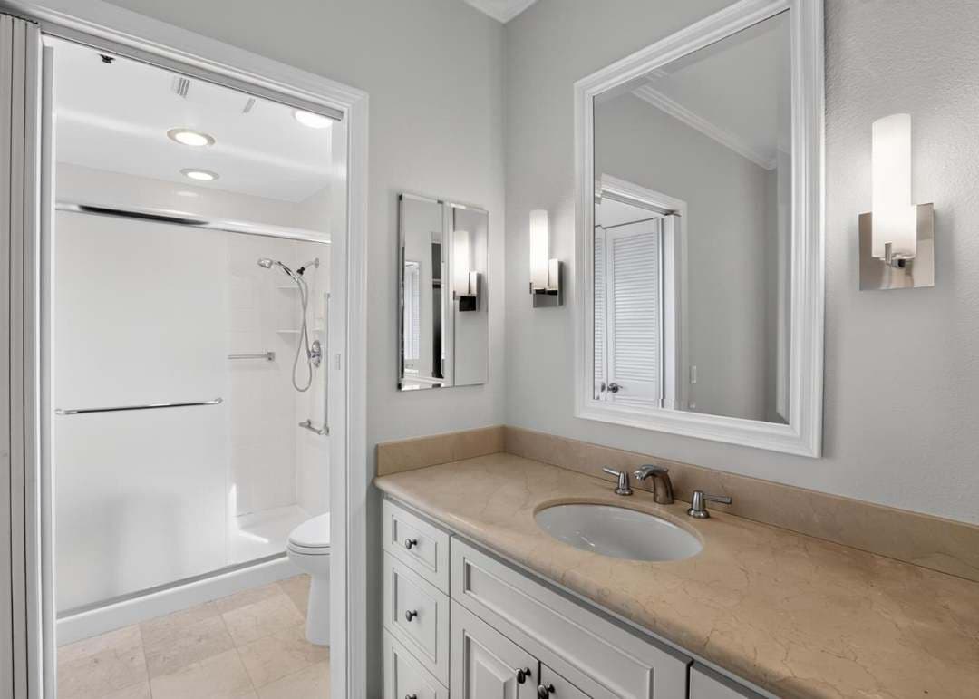 Bathroom with shower and vanity with white cabinetry