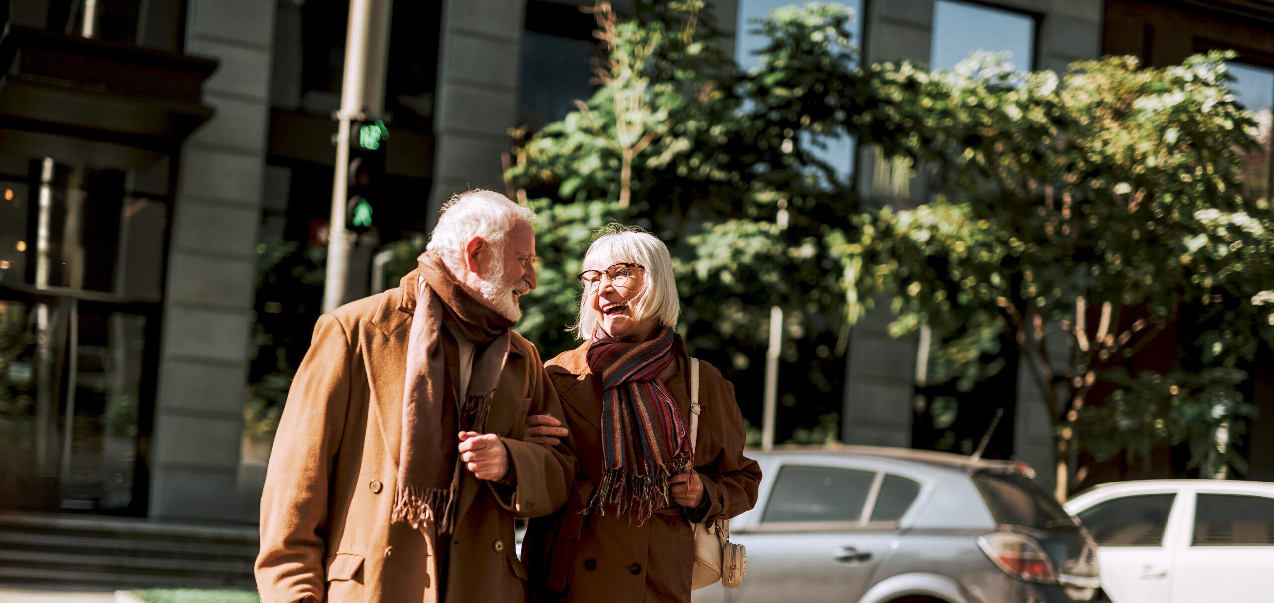 Happy older couple walk side by side on the street